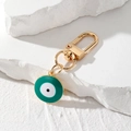 Detailansicht eines goldenen Schlüsselanhängers mit grünem Emaille Evil Eye Anhänger - Grün