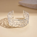 Macro detail van zilveren holle vervlochten textuur op minimalistische open manchetarmband - Hol Geweven Open Armband (Zilver)
