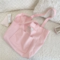 Detailaufnahme der rosa Canvas-Tasche mit Schleifenstickerei auf der Fronttasche - Hellrosa