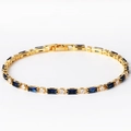 Detail eines Gold-Tennisarmbandes mit marineblauen Baguette-Steinen und weißen Diamanten - Königsblauer Zirkonia Gold