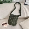 Detail of dark green faux shearling shoulder bag with white floral pattern on a sofa - Green (Polka Dot)