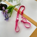Pink pet leash made of braided nylon rope with a durable plastic buckle on white desk - Red Strap