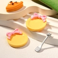 Miniature orange pizza slices on yellow plates with pink bows and silver cutlery set - Round Yellow Plate