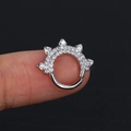 Anello piercing in argento con zirconi e punte a cono mostrato sul dito da donna - Argento