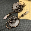 Detailed view of vintage bronze dragon filigree on a pink crystal round necklace pendant - Rose Quartz Dragon