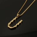 U-shaped initial pendant necklace in 18K gold plated stainless steel on black surface - Gold Letter U Pendant