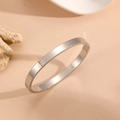 Detalle de brazalete plateado minimalista con bisagra sobre un soporte de piedra - 6mm de Ancho / Color Acero