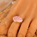 Pink seashell toe ring with gold metal rope band shown on sand for a beach vacation look - Pink Shell (3429) / Gold