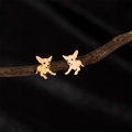 Roségoldene Chihuahua-Ohrstecker auf einem Ast vor schwarzem Hintergrund präsentiert - Chihuahua / Roségold