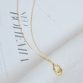 Elegante collar dorado con colgante geométrico sobre una revista de diseño minimalista - Dorado
