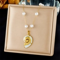 Detail of a conch pendant necklace with white pearls on a beige display stand - Metal Conch With White Shell (N3480)