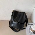 Chic black crocodile embossed bucket bag with a wide fabric strap and gold hardware - Black
