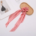 Detail of pink satin silk scrunchie with long scarf streamers on a wooden tray - Pink