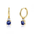 Macro shot of gold-plated hoop earrings featuring deep blue round-cut zircon pendants - Blue Zirconia