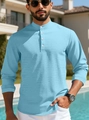 Outdoor lifestyle shot showing the waffle knit texture and four-button henley collar - Light Blue