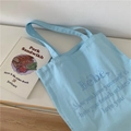 Detail der hellblauen Canvas-Tasche mit Fokus auf die dichte Baumwolltextur und Bestickung - Hellblau