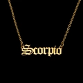 Detailed close-up of golden Scorpio necklace with Gothic letter pendant on black background - Scorpio - Gold