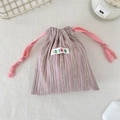 Gros plan détaillé du sac de rangement rayé à cordon rose et étiquette en tissu sozakka - Rayé Jacquard Rose