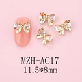 Macro view of 11.5x8mm gold heart bow nail charms with amber rhinestones on a pink tip - Gold Base Champagne (AC17)
