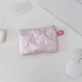 Close-up of pink quilted makeup pouch with bow pattern on a desk with laptop - Bow Quilted Pink Coin Purse