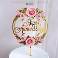 Detailed view of a 10.5cm Happy Anniversary cake topper with pink roses and gold frame - Round Happy Anniversary