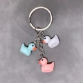 Three colorful resin duck charms in white, blue, and pink on a silver metal keychain - Mixed 3 Pcs Set / Blue White Pink