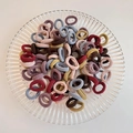 Set of high-elasticity cartoon hair ties in Morandi earth tones displayed on a glass plate - Korean Style Color 100Pcs OPP Bag
