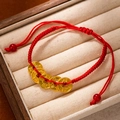 Detailed shot of red braided rope bracelet with five gold coins on beige velvet display - L269-9 Kangxi & Qianlong Prosperity
