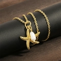 Détail macro du pendentif étoile de mer plaqué or 18K avec perle baroque sur soie - Doré
