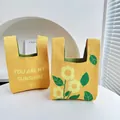 Gestrickte Sonnenblumen-Handtaschen mit Text und Blumenmustern auf weißem Tisch - Sonnenblume