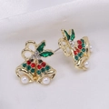 Macro shot of gold festive bell earrings with red and green rhinestones on white satin - Pearl Bell 2