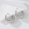 Pendientes de aro tipo croissant en acero inoxidable plateado sobre fondo de piedra blanca - Color Acero