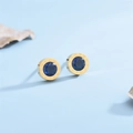 Makroaufnahme goldener Ohrstecker mit römischen Ziffern und marineblauen Steinen - Blau
