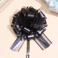 Detail of elegant black and gold pull bow with satin ribbon and metallic mesh edges - Black