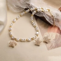 Detail view of gold star charms and white pearl necklace with matching earrings - Gold Pearl Star Set