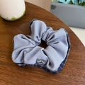 Detail of blue plaid fabric hair scrunchie with Hand Made label on a wooden table - Blue Plaid Edge Light Blue Bow Scrunchie