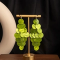Detail of lime green resin disc drop earrings on a minimalist gold display stand - H3478-2 Style