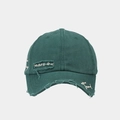 Detailed macro view of distressed fabric and white embroidery on a green cotton baseball cap - Green