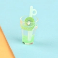 Macro view of a miniature kiwi drink charm with green resin slices and a tiny straw - Kiwi