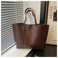 Close-up of a large brown leather tote bag with elegant vertical stitching and a soft texture - Coffee