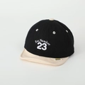 Detail view of baby baseball cap with Est. Number 23 embroidery and yellow brand tag - 50cm (1-3 Years) / Black (Number 23)