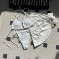 Three-piece white bikini set with textured fabric top, bottom, and matching mini skirt - White