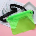 Fluorescent green waterproof phone bag with adjustable black strap on colorful background - Waterproof Waist Bag / Green
