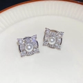 Exquisite silver-tone earrings featuring a central round pearl and cubic zirconia halo - Silver