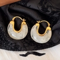 Detail of vintage U-shaped metal earrings with white cloudy resin on black silk fabric - Gold/Cloudy White Transparent Resin