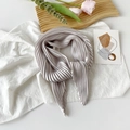 Elegant grey pleated silk scarf tied neatly on a wooden tray with floral accents - 70*70cm / Pleated Silver White