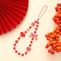 Detail of red beaded phone strap with heart, star, and bow charms on warm background - K2889 Chinese Style Bow Phone Chain
