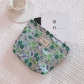 Floral fabric storage pouch with metal zipper and printed label on white background - Green