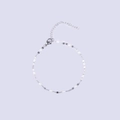 Detailed macro view of thin silver chain bracelet with white enamel oval accents and clasp - Steel + White