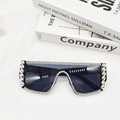 Détail de lunettes de soleil noires avec strass argentés sur textile blanc - Monture Noire Gris Complet